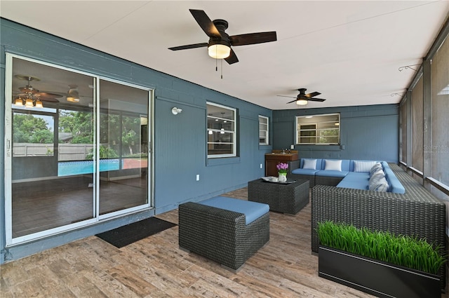 wooden terrace with outdoor lounge area and a ceiling fan