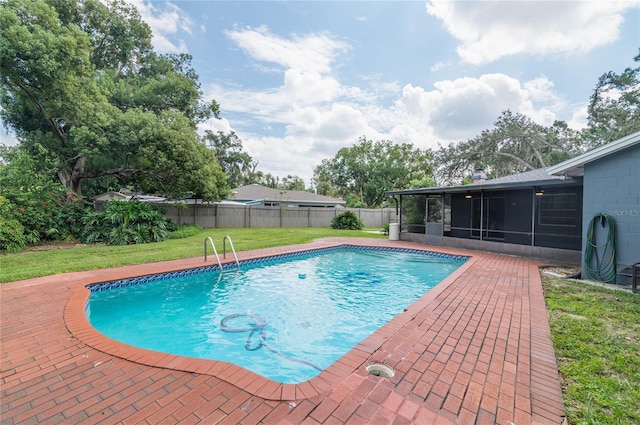 view of swimming pool featuring a fenced backyard, a sunroom, a lawn, a fenced in pool, and a patio area