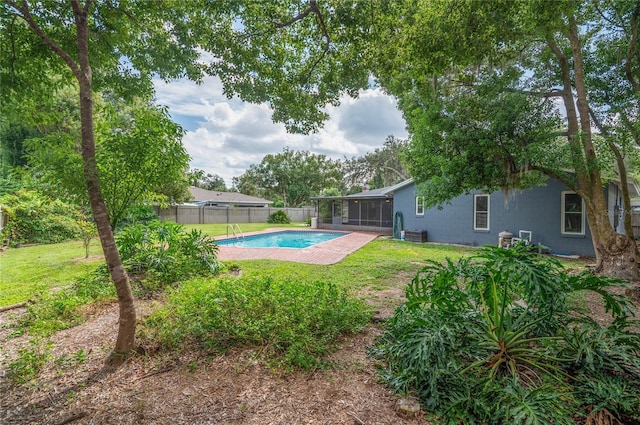 view of swimming pool with a fenced in pool, a sunroom, a yard, and fence