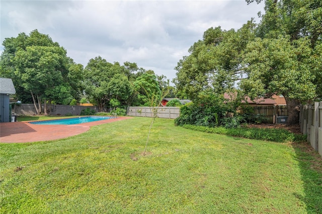 view of yard with a fenced in pool, a fenced backyard, and a patio