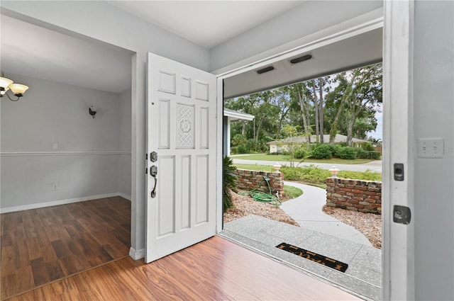 foyer entrance featuring baseboards and wood finished floors