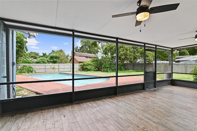 unfurnished sunroom with a ceiling fan