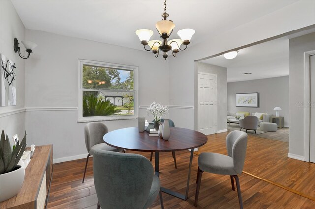 dining area with an inviting chandelier, baseboards, and wood finished floors