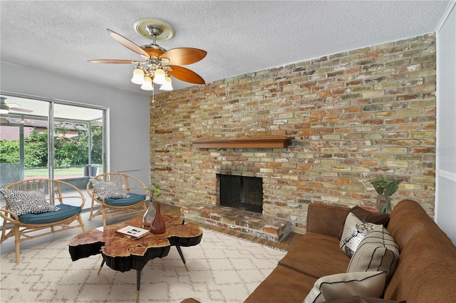 living room with a textured ceiling, a fireplace, a ceiling fan, and wood finished floors