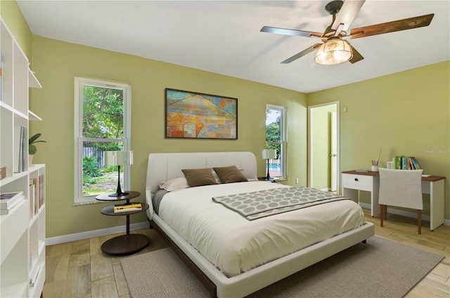 bedroom with baseboards, ceiling fan, and light wood finished floors