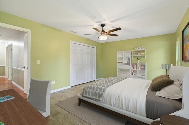 bedroom featuring baseboards, visible vents, ceiling fan, wood finished floors, and a closet