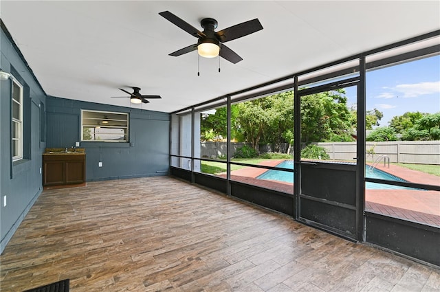 unfurnished sunroom with a sink, plenty of natural light, visible vents, and a ceiling fan