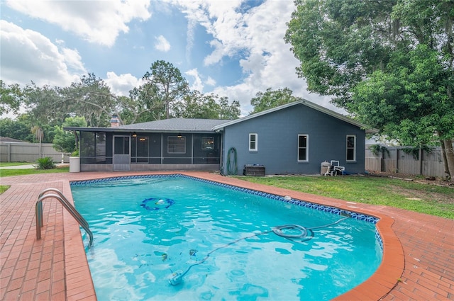 view of pool featuring a lawn, a fenced backyard, a sunroom, and a fenced in pool