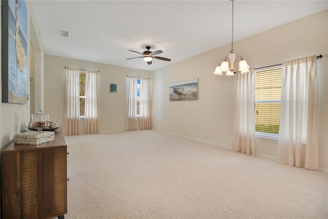 interior space featuring ceiling fan with notable chandelier