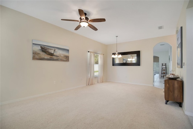 1033 Hacienda Cir, Kissimmee, FL 34741 - empty room with visible vents, baseboards, arched walkways, ceiling fan with notable chandelier, and light colored carpet