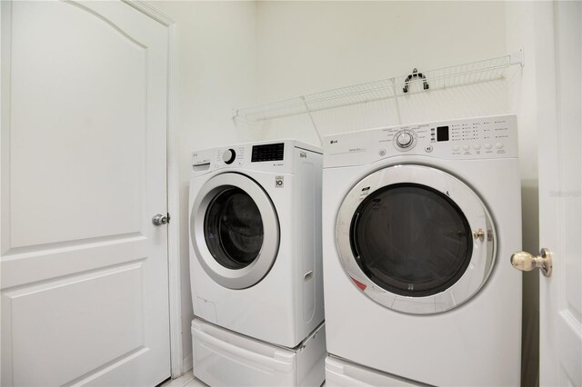 1033 Hacienda Cir, Kissimmee, FL 34741 - washroom with washer and dryer and laundry area