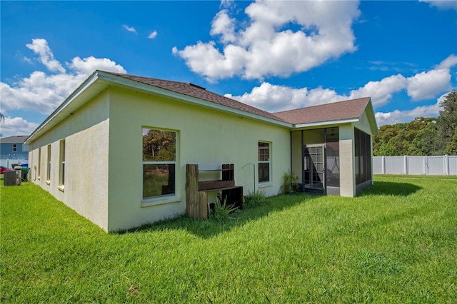 1033 Hacienda Cir, Kissimmee, FL 34741 - back of property with a yard, fence, a sunroom, and stucco siding