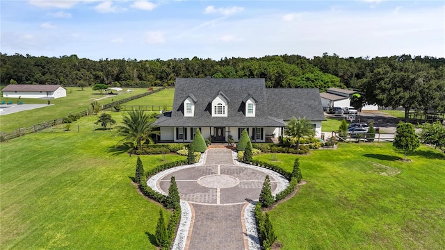 cape cod house with a front yard and covered porch