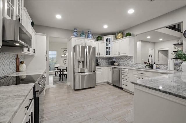 kitchen featuring white cabinets, sink, appliances with stainless steel finishes, and light stone countertops