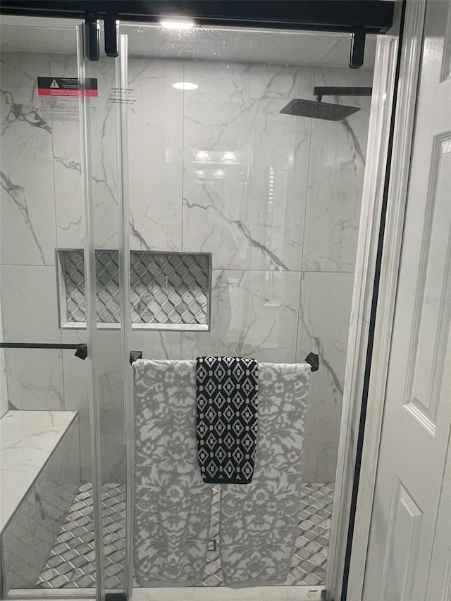 bathroom with a shower with door