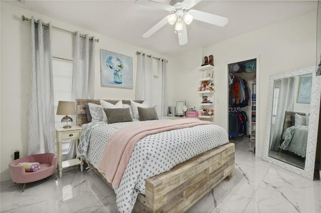 bedroom featuring a walk in closet, a closet, and ceiling fan