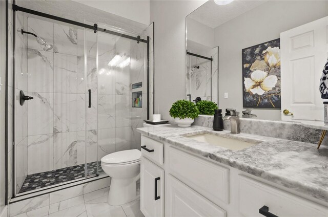 bathroom featuring vanity, toilet, and a shower with shower door