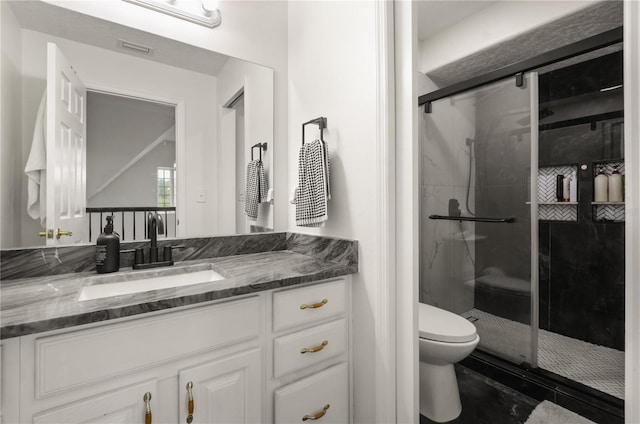 bathroom featuring tile patterned floors, a shower with door, vanity, and toilet