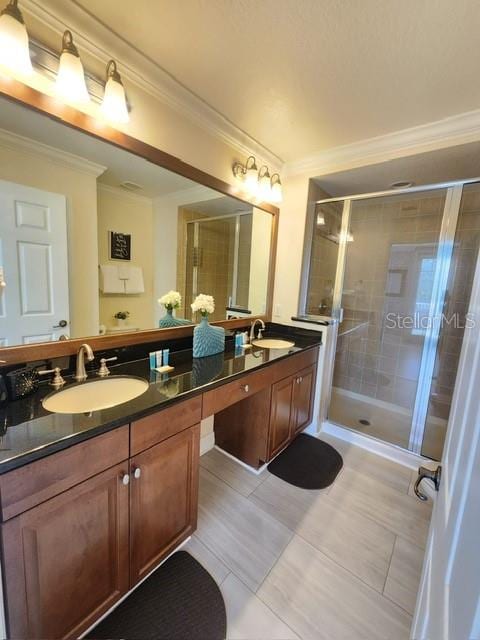 bathroom featuring tile patterned floors, vanity, a shower with shower door, and crown molding