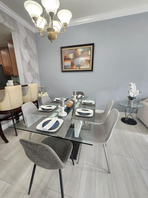 dining room with crown molding and a chandelier