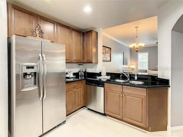 kitchen with stainless steel appliances, crown molding, sink, dark stone countertops, and a chandelier