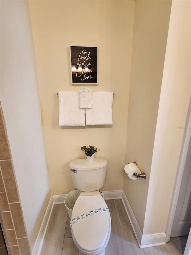 bathroom featuring hardwood / wood-style flooring and toilet