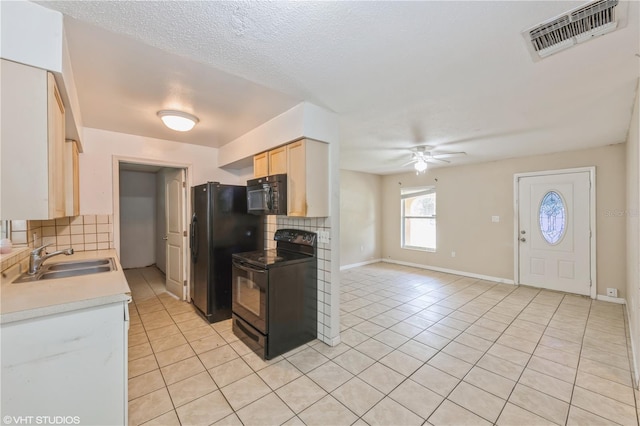 kitchen with decorative backsplash, light tile patterned flooring, black appliances, ceiling fan, and sink