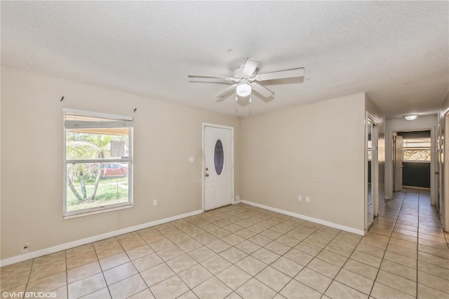 tiled spare room featuring ceiling fan and a textured ceiling