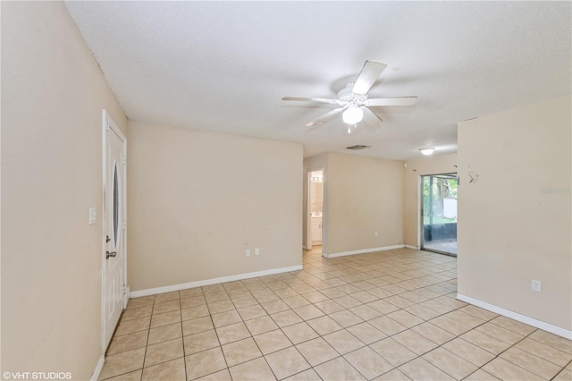 spare room with ceiling fan, a textured ceiling, and light tile patterned floors