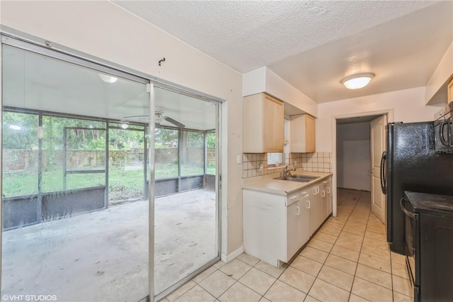 kitchen featuring a textured ceiling, tasteful backsplash, sink, black appliances, and ceiling fan