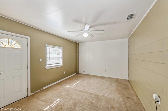 foyer entrance featuring a wealth of natural light, ceiling fan, and carpet floors