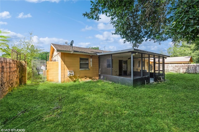 rear view of property with a sunroom and a yard