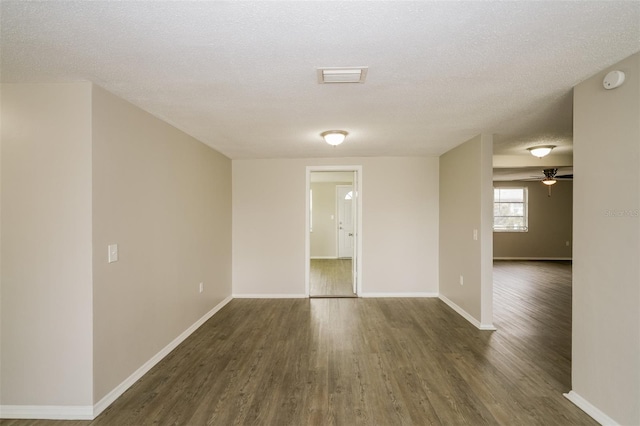 unfurnished room with ceiling fan, a textured ceiling, and dark hardwood / wood-style flooring