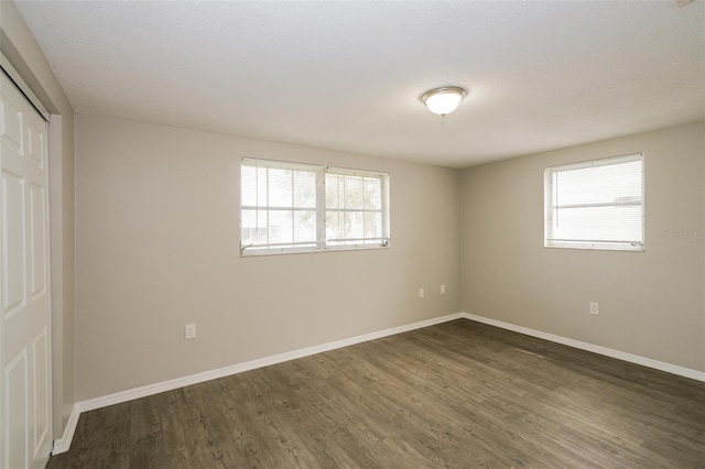 unfurnished bedroom with a closet, dark hardwood / wood-style floors, and a textured ceiling