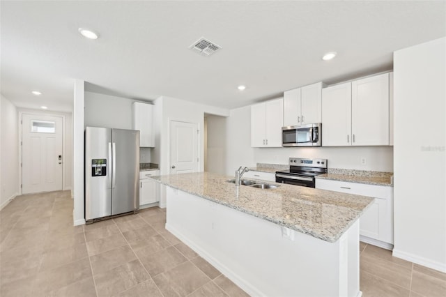 kitchen featuring white cabinets, appliances with stainless steel finishes, a center island with sink, and sink