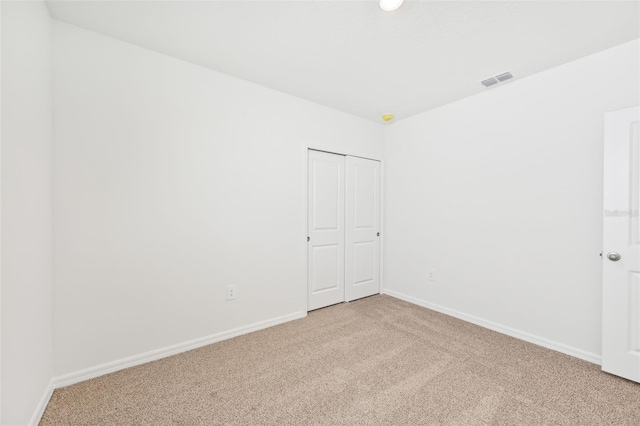 unfurnished room featuring light colored carpet