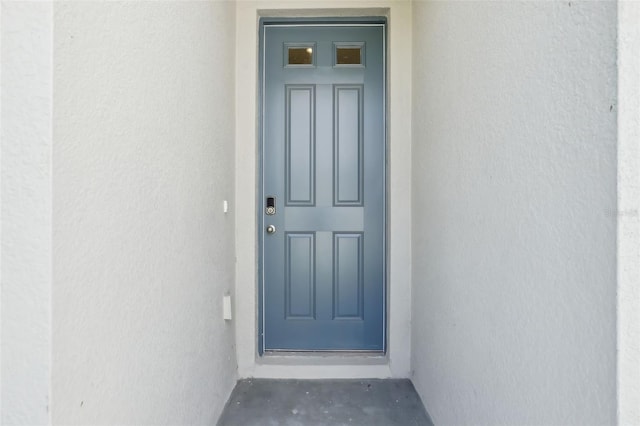 entrance to property with stucco siding