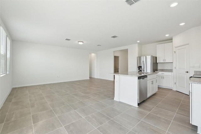 kitchen with open floor plan, a center island with sink, recessed lighting, stainless steel appliances, and white cabinetry