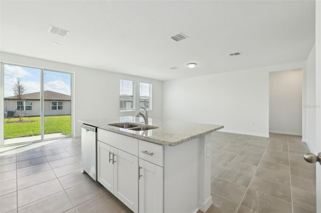 kitchen featuring light stone counters, a sink, visible vents, and stainless steel dishwasher