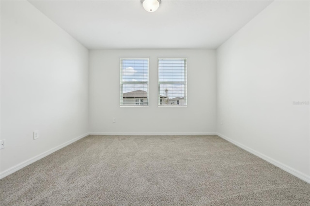 unfurnished room featuring baseboards and carpet