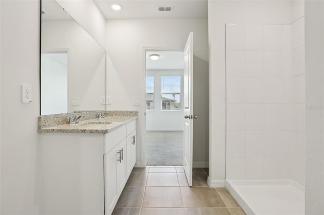 full bathroom featuring baseboards, visible vents, double vanity, a sink, and tile patterned flooring