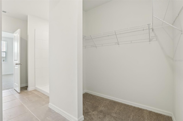 spacious closet with light tile patterned flooring and light carpet