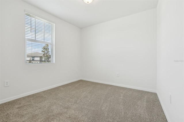 carpeted empty room with baseboards