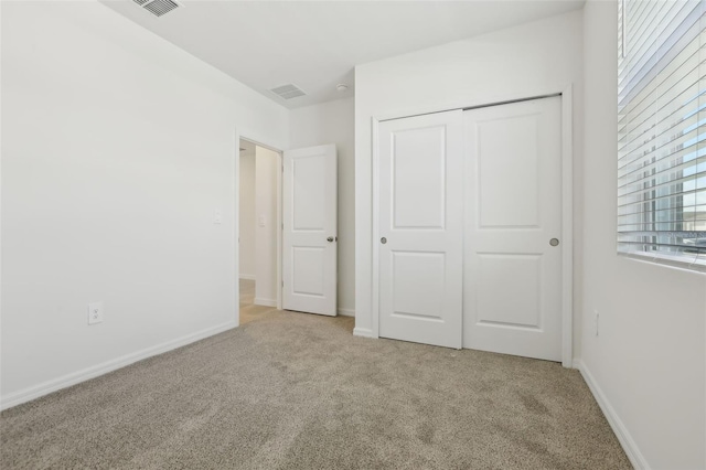 unfurnished bedroom featuring a closet, visible vents, baseboards, and carpet