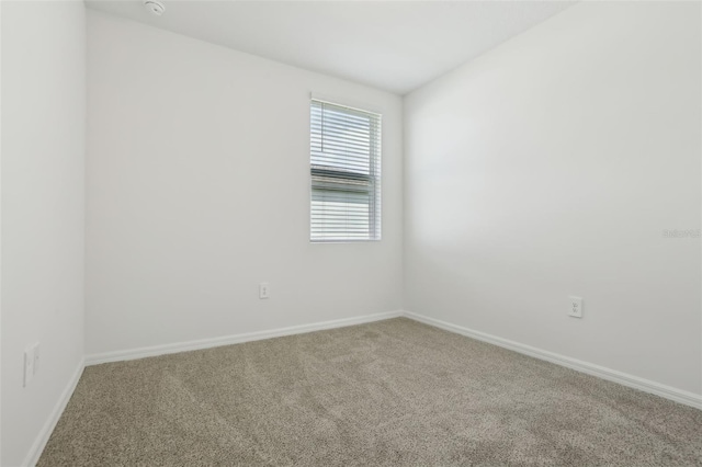 spare room with carpet and baseboards