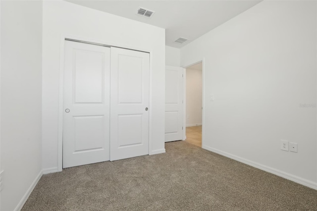 unfurnished bedroom featuring visible vents, baseboards, a closet, and carpet flooring