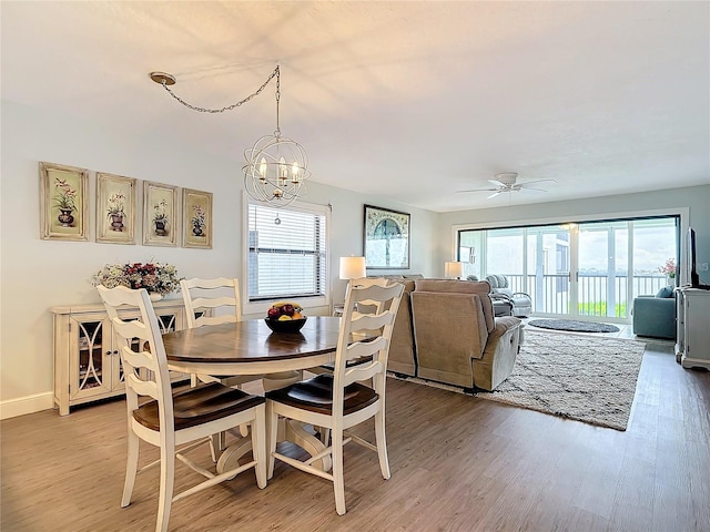 dining room with ceiling fan with notable chandelier and hardwood / wood-style floors