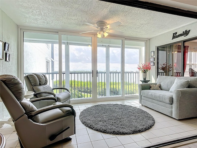 sunroom / solarium featuring a water view and ceiling fan