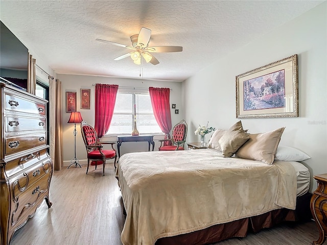 bedroom featuring wood-type flooring, ceiling fan, and a textured ceiling