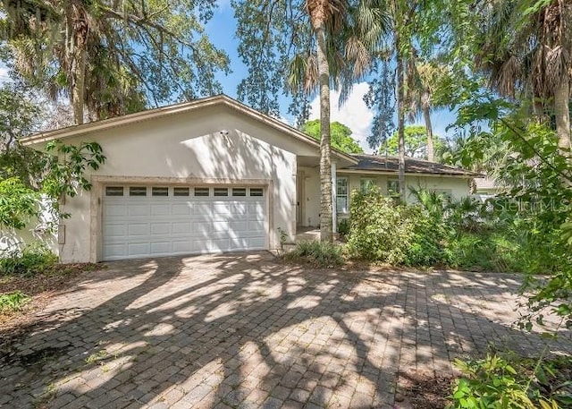 single story home with stucco siding, driveway, and a garage